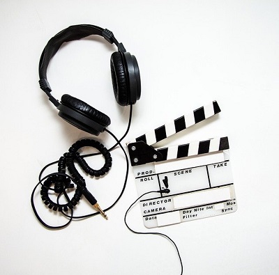 Random image about multimedia, showing headphones and a director's clapperboard